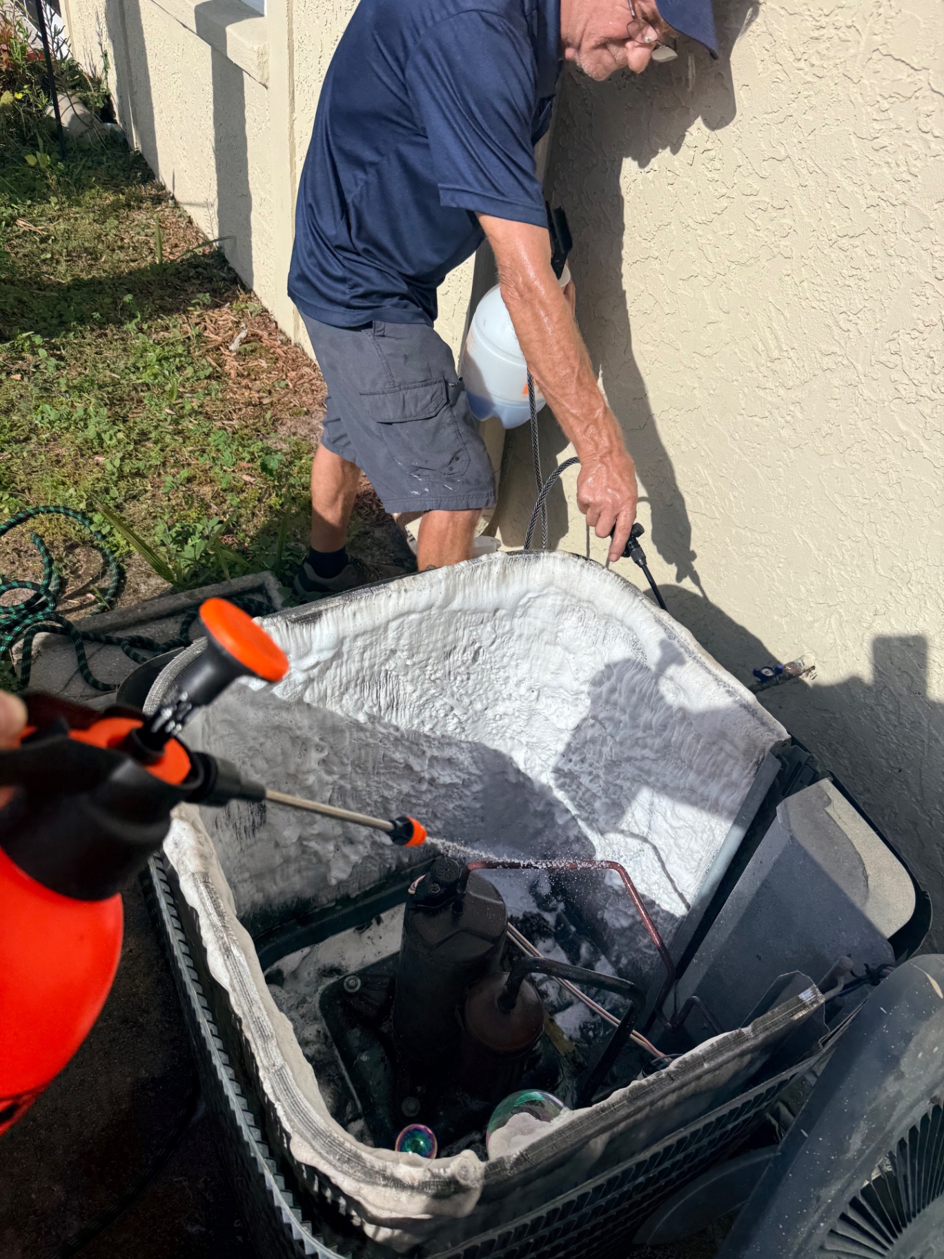 Applying foaming coil cleaner to an outdoor AC condenser on a Treasure Coast maintenance visit