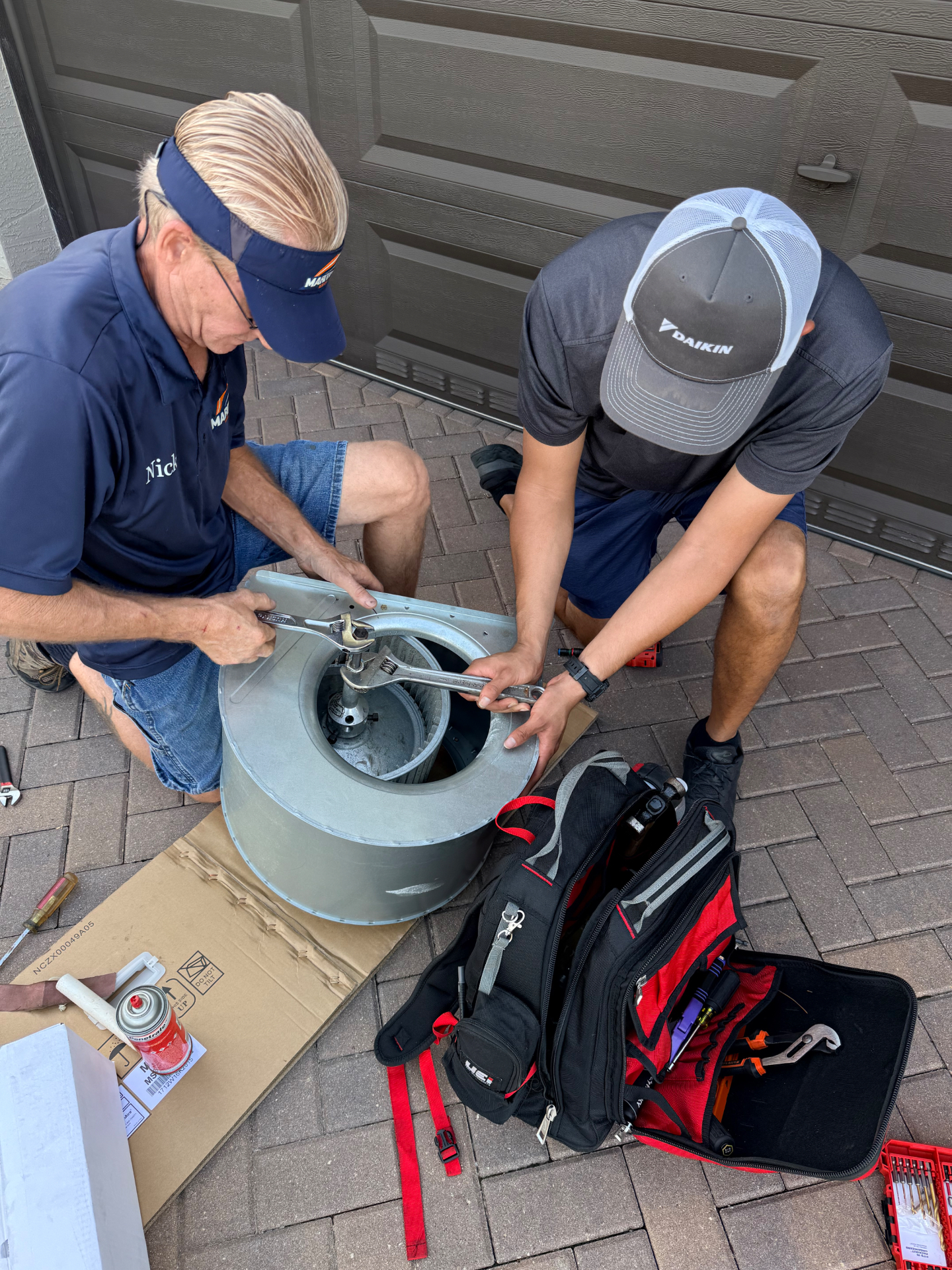 Nick and Daniel field training on a blower wheel and motor service in a Treasure Coast garage