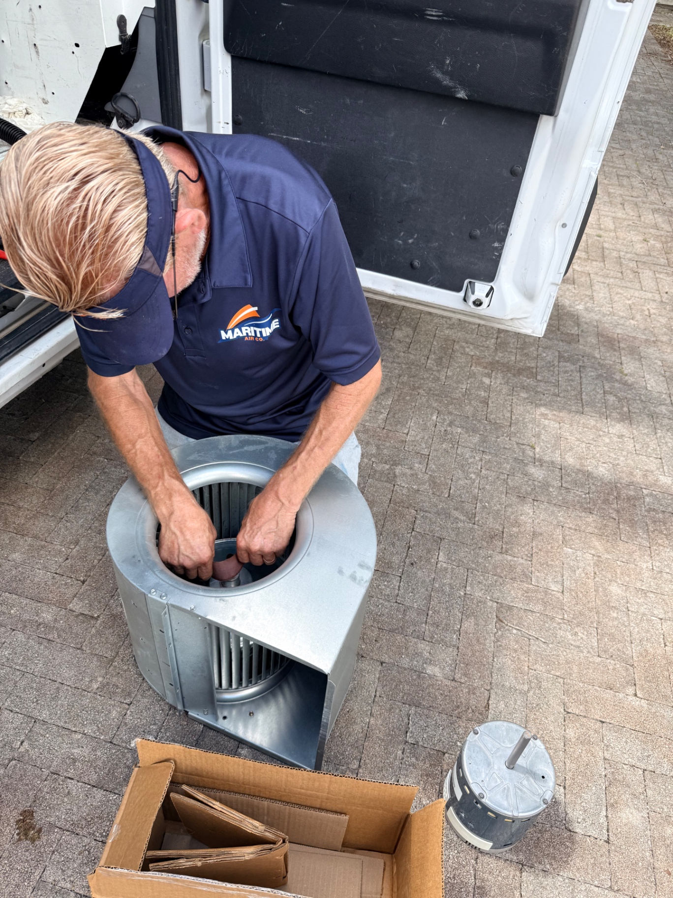 Maritime Air Co. technician performing a Rheem warranty blower motor replacement on a residential HVAC system