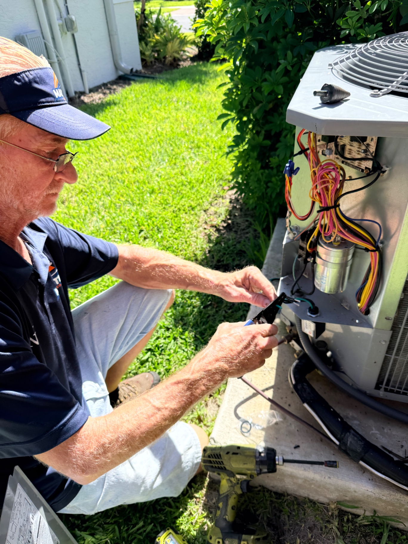 Maritime Air Co. technician installing a condenser surge protector on a residential unit in Valencia Walk, FL
