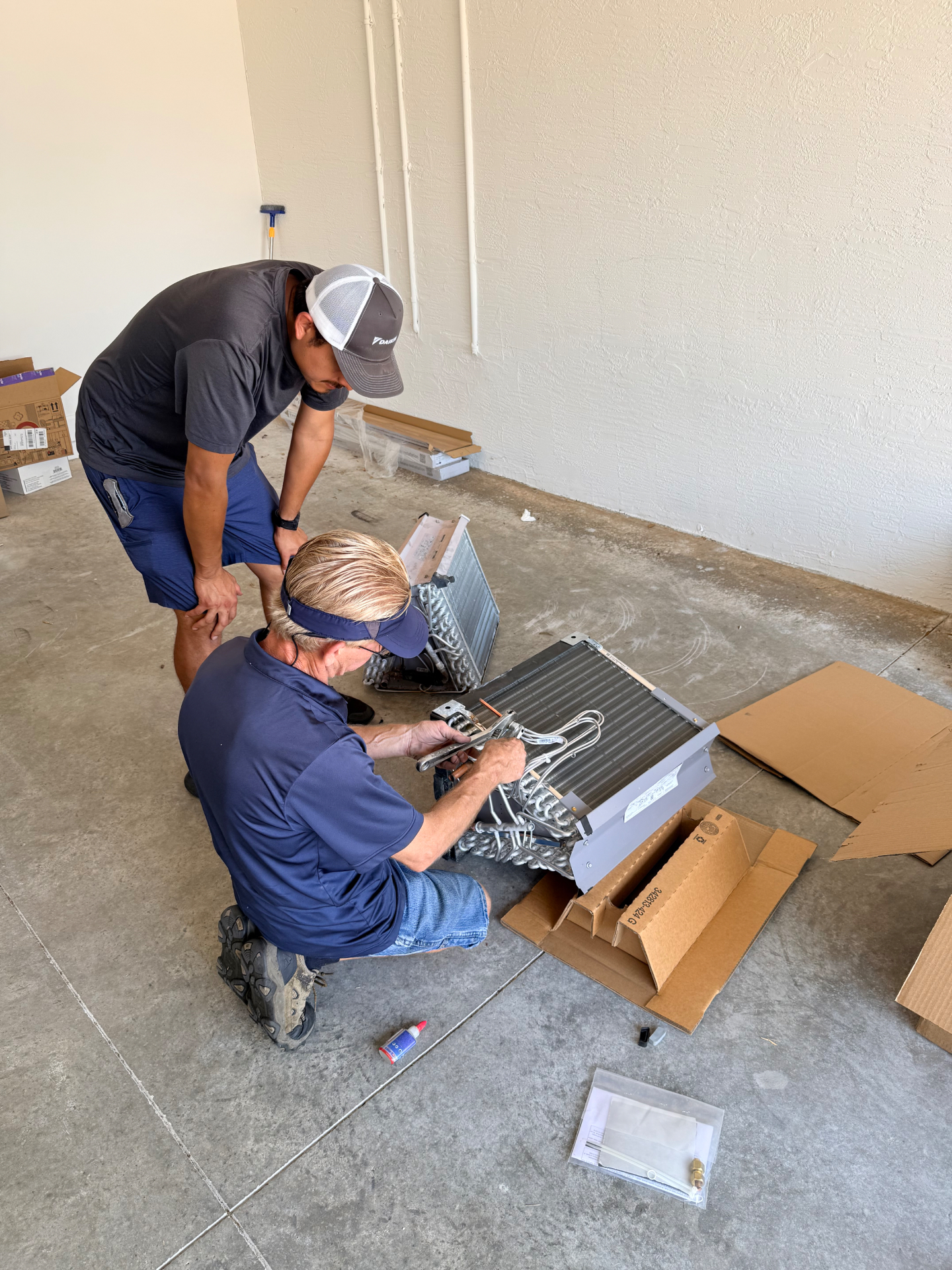 Devon and Nick hands-on field training with a residential coil assembly in a Treasure Coast garage