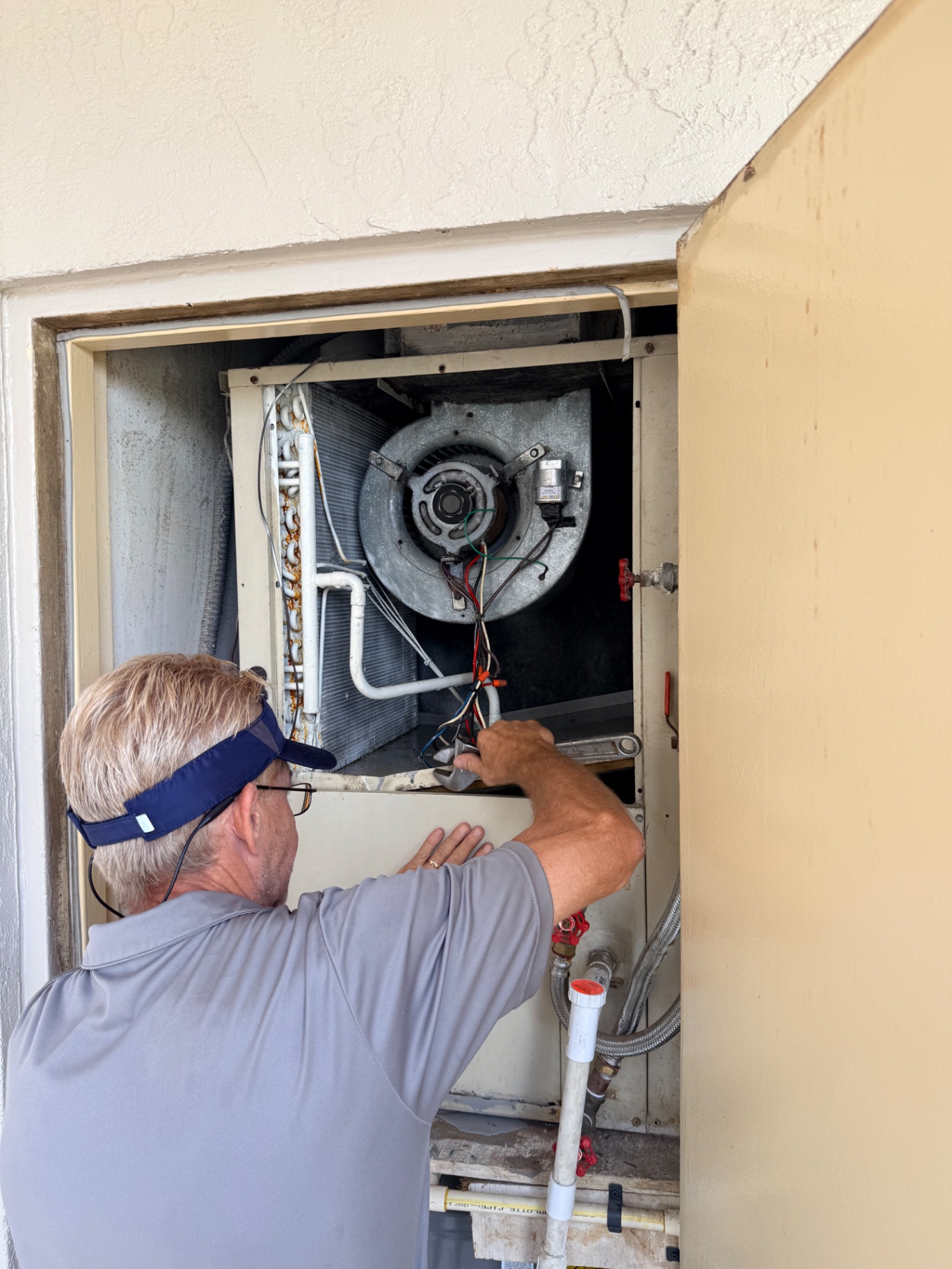 Servicing exterior closet air handler blower motor in Fort Pierce, FL
