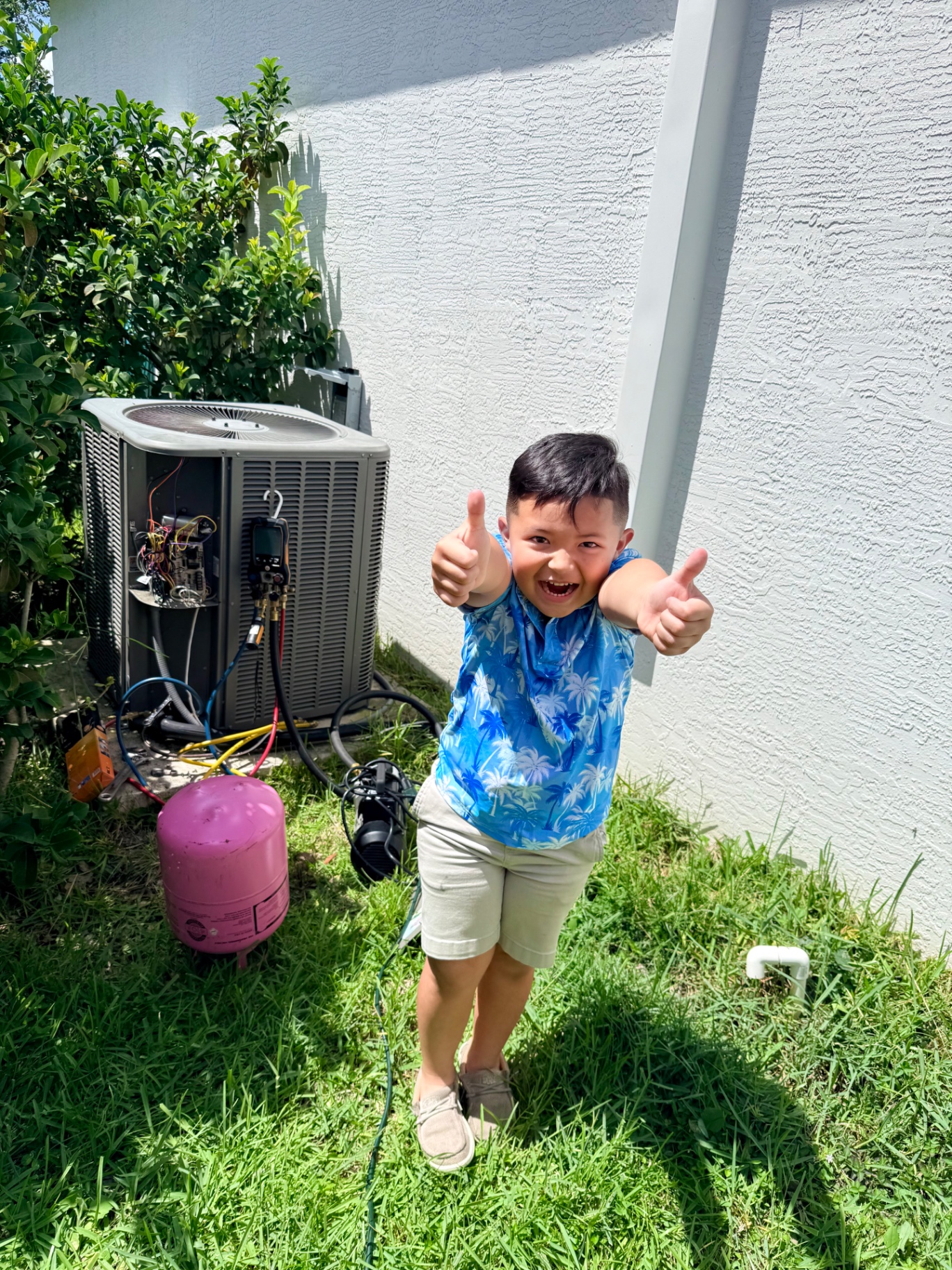 Young Melice son giving two thumbs up next to a Maritime Air Co. AC service job in Fort Pierce, Florida