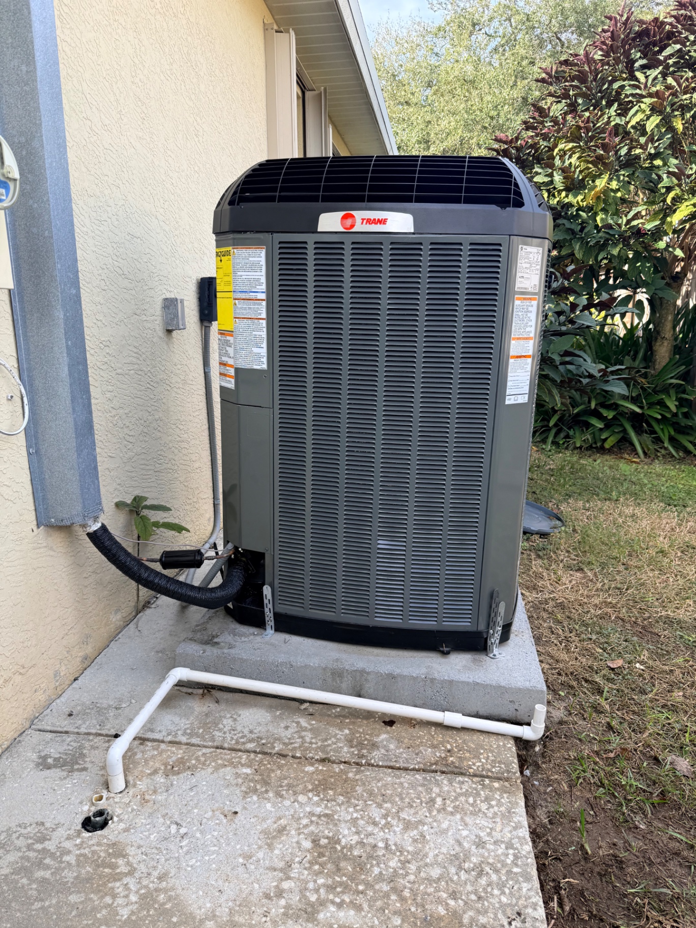 Trane variable-speed condenser installed on concrete pad outside Treasure Coast home