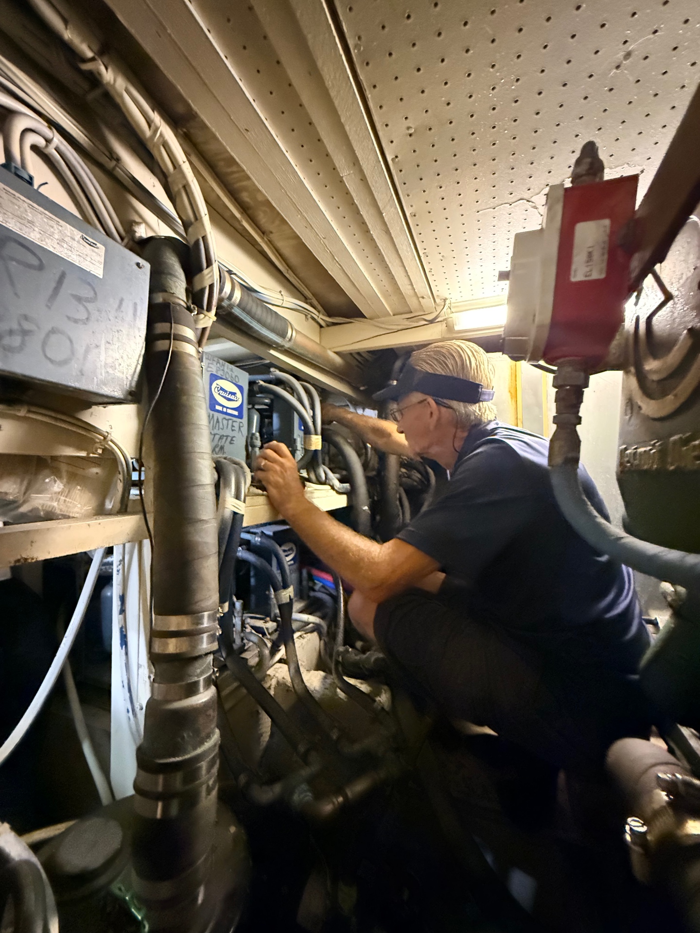Maritime Air technician repairing a 1970s R-22 Dometic Cruiseair marine HVAC system in a tight engine room